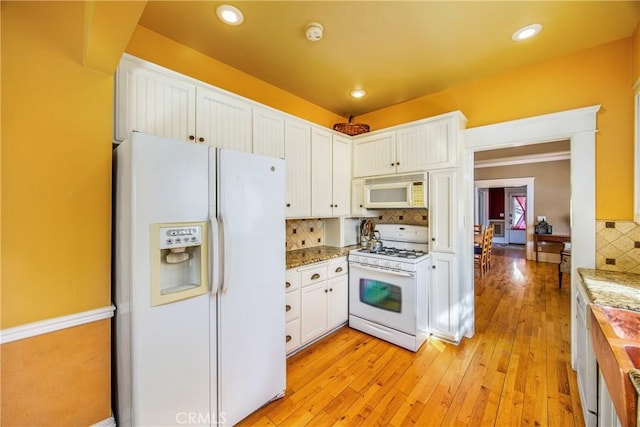 kitchen with white cabinetry, butcher block counters, backsplash, white appliances, and light hardwood / wood-style flooring