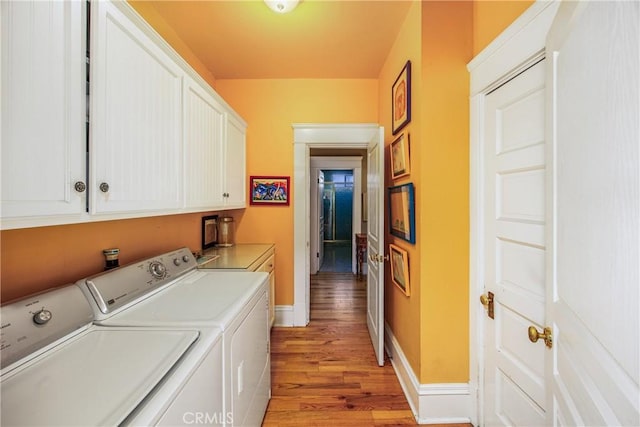 laundry room featuring cabinets, light hardwood / wood-style floors, and washer and dryer