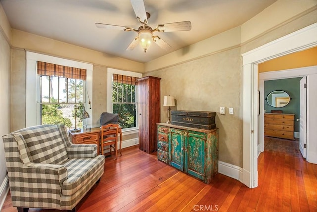 living area with dark wood-type flooring and ceiling fan