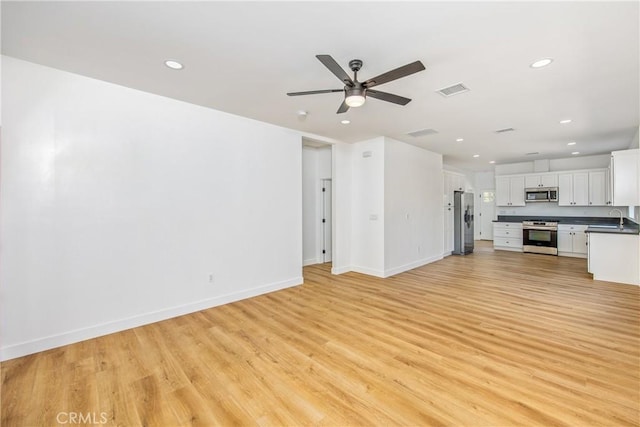 unfurnished living room featuring sink, light hardwood / wood-style flooring, and ceiling fan