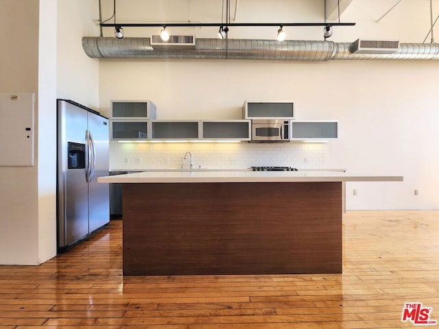 kitchen with dark wood-type flooring, appliances with stainless steel finishes, backsplash, and sink