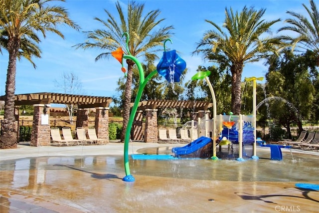 community play area featuring fence and a pergola