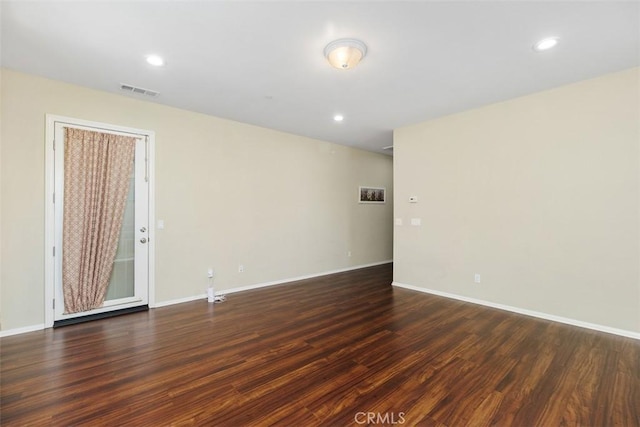 unfurnished room with dark wood-type flooring, recessed lighting, visible vents, and baseboards