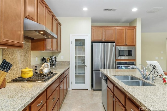 kitchen with stainless steel appliances, visible vents, decorative backsplash, a sink, and under cabinet range hood