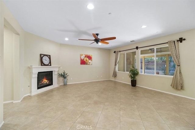 unfurnished living room featuring light tile patterned floors, recessed lighting, baseboards, and a glass covered fireplace