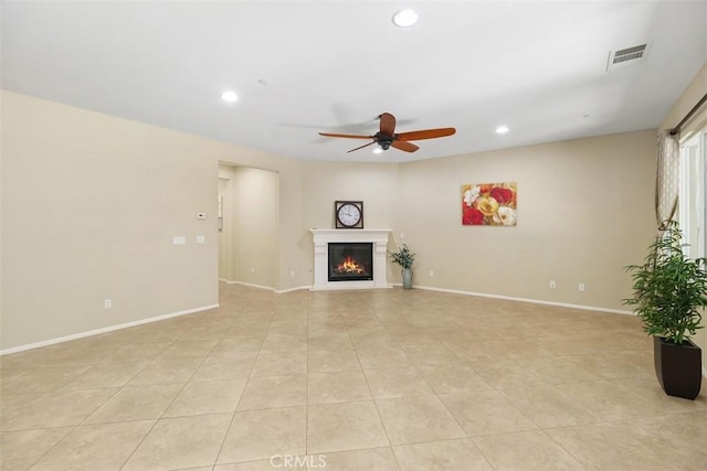 unfurnished living room featuring recessed lighting, visible vents, a lit fireplace, and baseboards