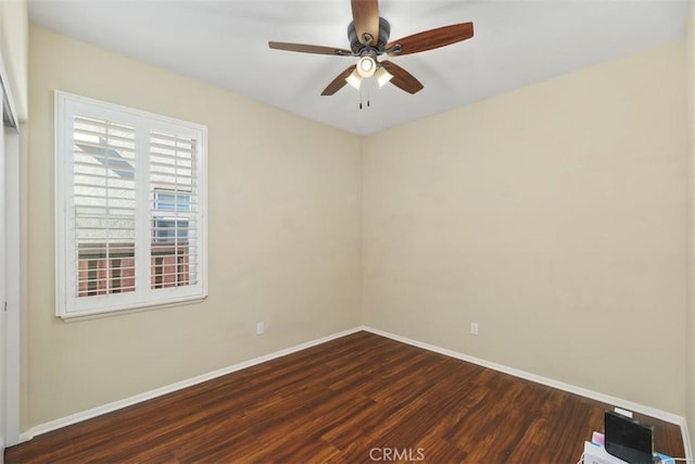 unfurnished room featuring dark wood finished floors, baseboards, and ceiling fan