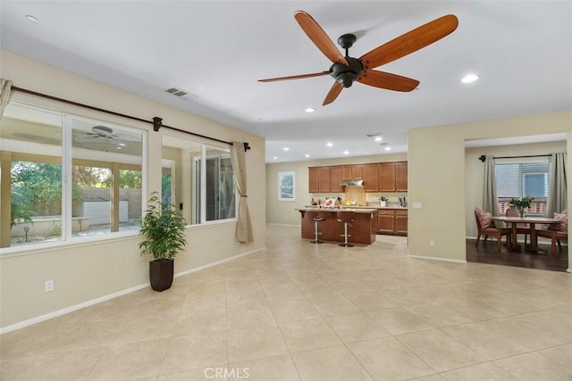 living room with recessed lighting, visible vents, plenty of natural light, and baseboards