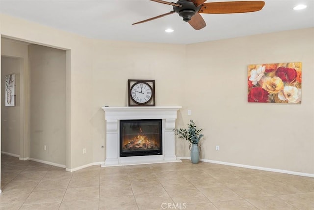 unfurnished living room featuring baseboards, a ceiling fan, and a glass covered fireplace