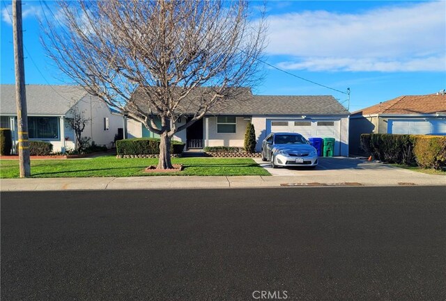 ranch-style home featuring a front lawn and a garage