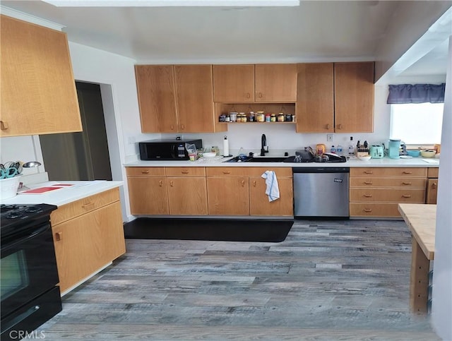 kitchen featuring black appliances, dark hardwood / wood-style flooring, and sink