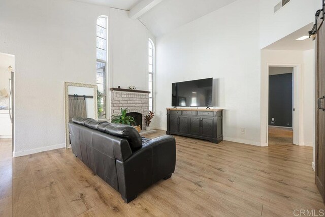 living room featuring beamed ceiling, high vaulted ceiling, and light hardwood / wood-style flooring