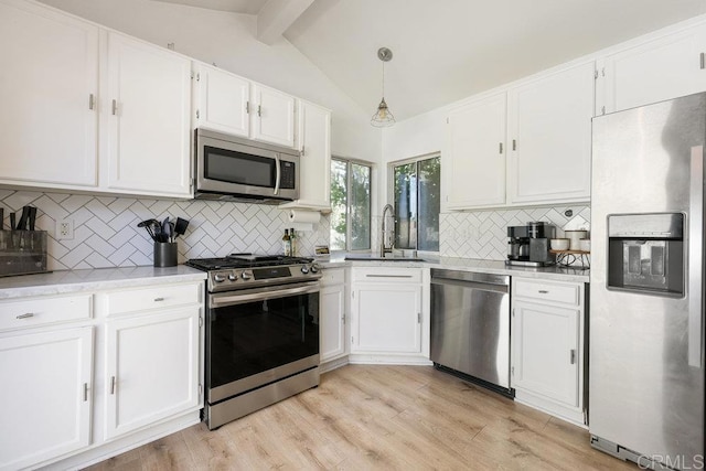 kitchen with sink, lofted ceiling with beams, white cabinets, and appliances with stainless steel finishes