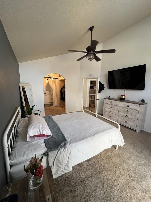 bedroom featuring vaulted ceiling, carpet floors, a textured ceiling, and ceiling fan