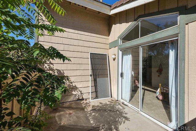 view of exterior entry with a patio