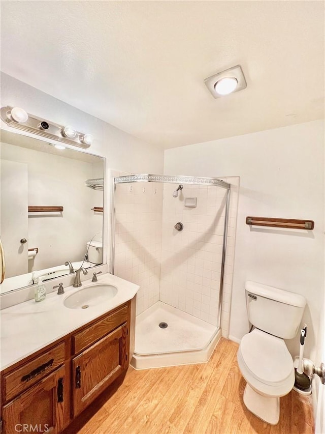 bathroom with vanity, toilet, wood-type flooring, and walk in shower