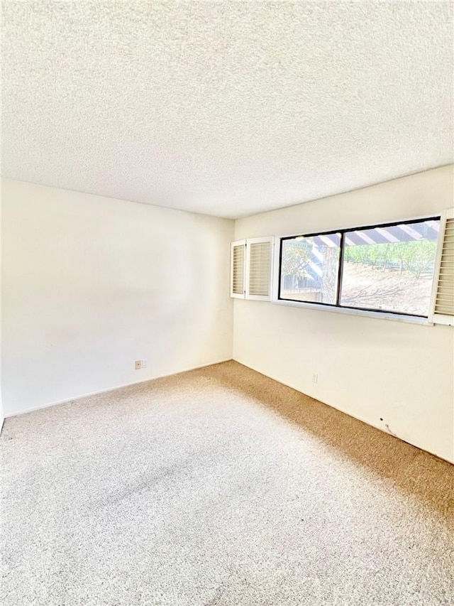 carpeted spare room with a textured ceiling