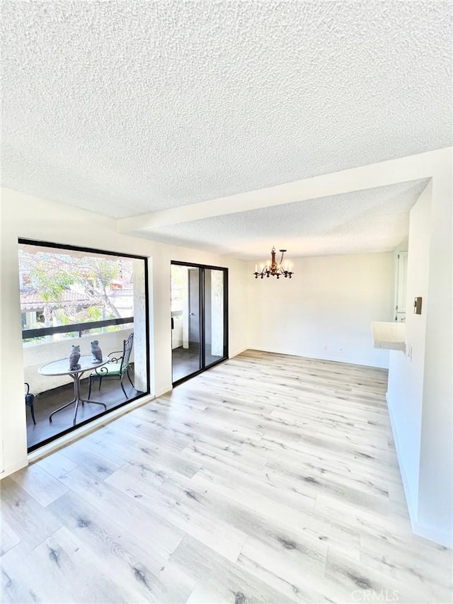 1 Cabrillo Dr, Avalon, CA 90704 - empty room featuring a textured ceiling, a chandelier, light wood finished floors, and baseboards