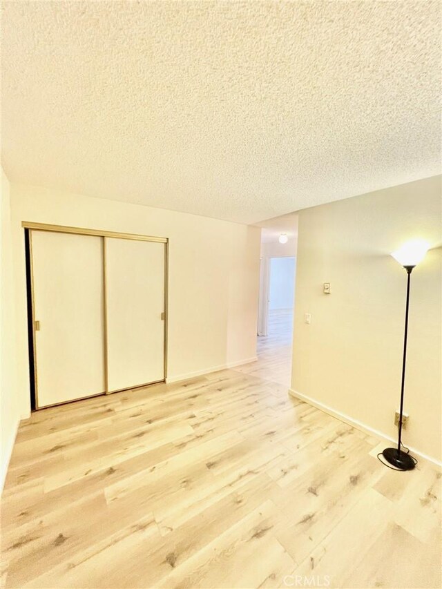 1 Cabrillo Dr, Avalon, CA 90704 - below grade area featuring light wood finished floors, a textured ceiling, and baseboards