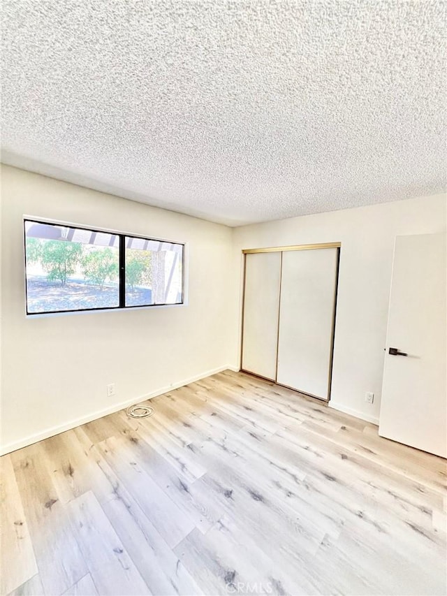 1 Cabrillo Dr, Avalon, CA 90704 - unfurnished bedroom with wood finished floors, a closet, a textured ceiling, and baseboards
