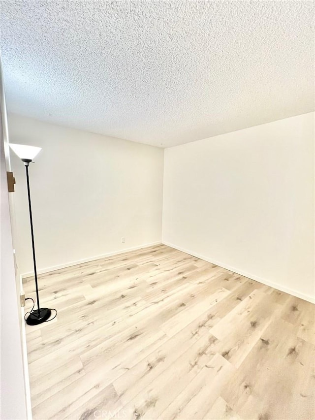 1 Cabrillo Dr, Avalon, CA 90704 - spare room featuring a textured ceiling, light wood-type flooring, and baseboards