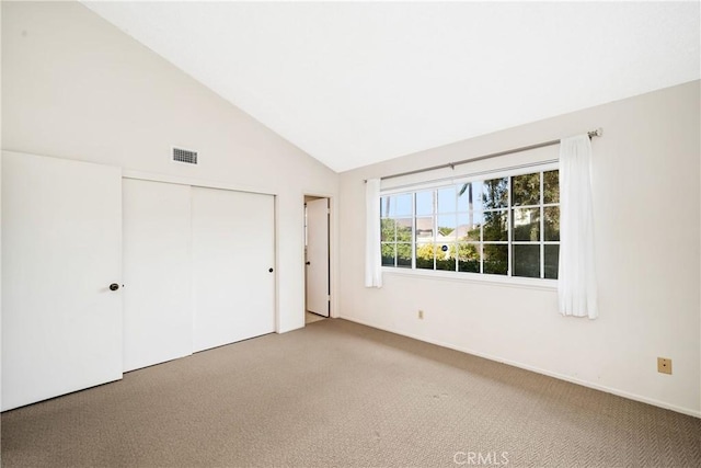 unfurnished bedroom featuring carpet flooring, a closet, and lofted ceiling