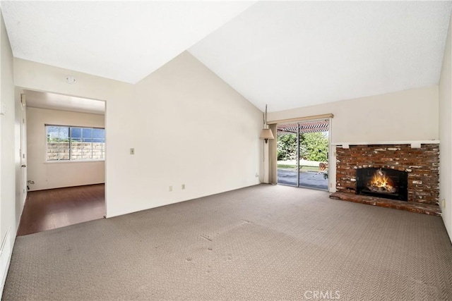 unfurnished living room with high vaulted ceiling, carpet flooring, and a fireplace