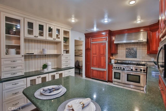 kitchen with ventilation hood, high end appliances, tasteful backsplash, and white cabinets