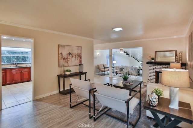 living room with crown molding, ceiling fan, sink, and light wood-type flooring