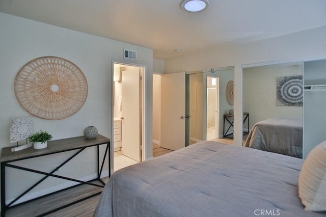 bedroom featuring a barn door and ensuite bathroom