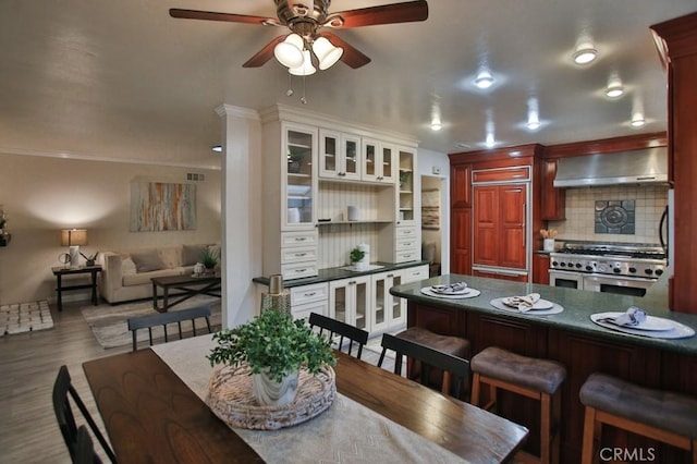 dining space featuring wood-type flooring and ceiling fan