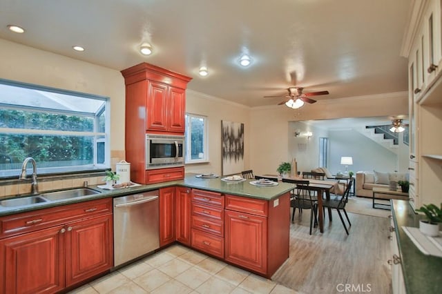 kitchen with sink, ornamental molding, appliances with stainless steel finishes, kitchen peninsula, and ceiling fan