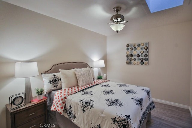 bedroom with dark wood-type flooring and a skylight