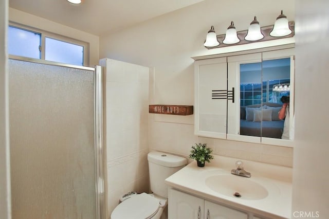 bathroom with vanity, toilet, an enclosed shower, and backsplash