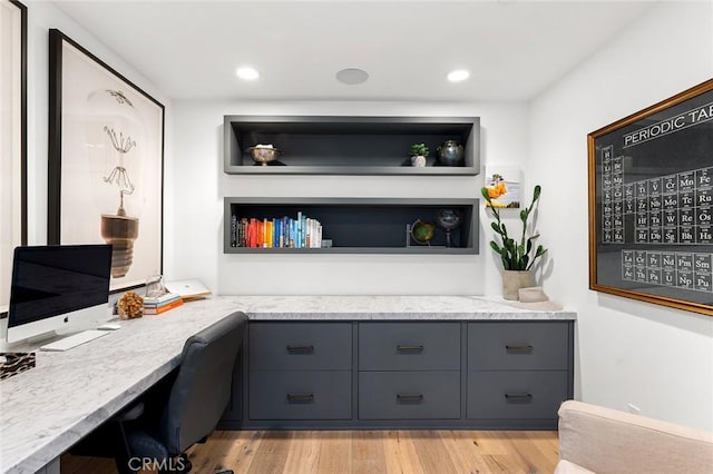 office with light hardwood / wood-style floors and built in desk