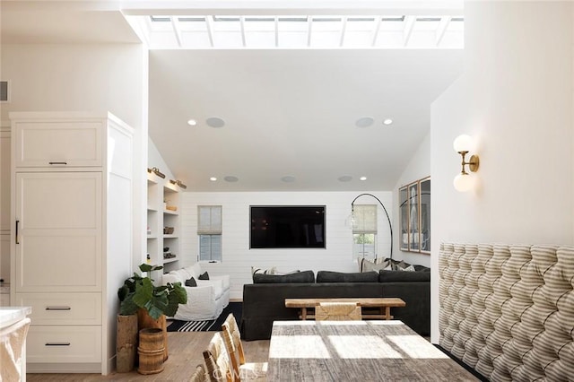 living room with built in shelves and lofted ceiling