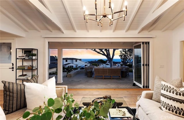 entryway featuring lofted ceiling with beams, wood-type flooring, and a chandelier