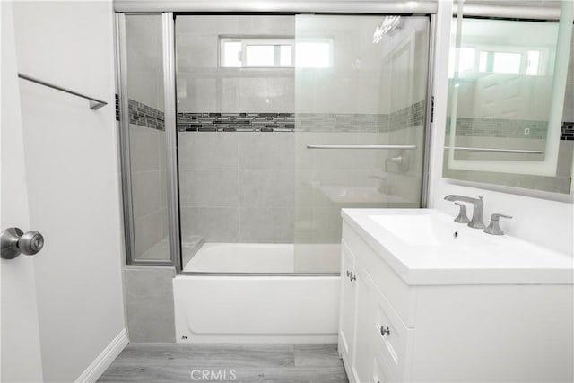 bathroom with enclosed tub / shower combo and vanity