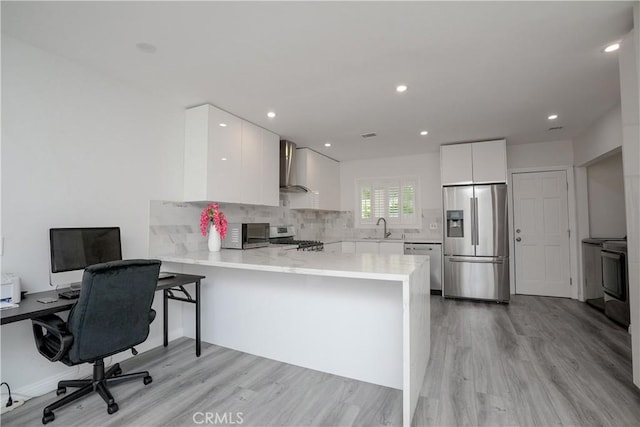 kitchen featuring appliances with stainless steel finishes, white cabinets, kitchen peninsula, and sink