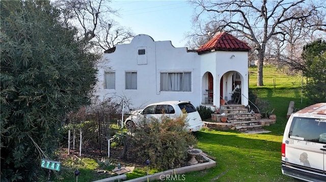 mediterranean / spanish home with a front lawn