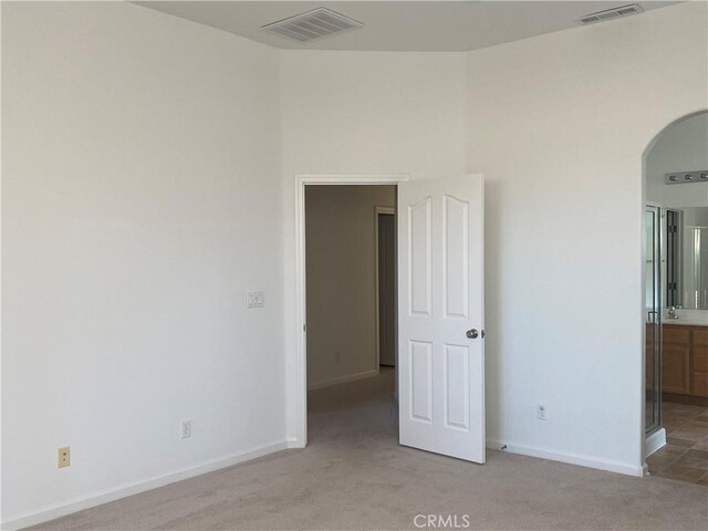 empty room featuring sink and light carpet