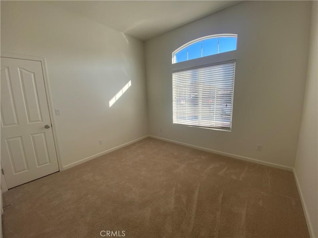 unfurnished room featuring carpet and baseboards