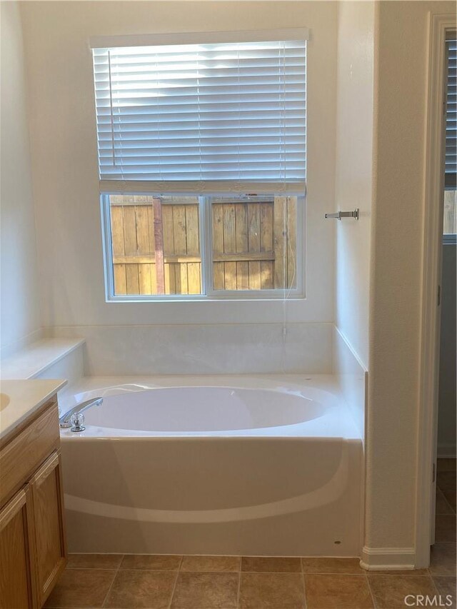 bathroom with a tub, tile patterned flooring, and vanity