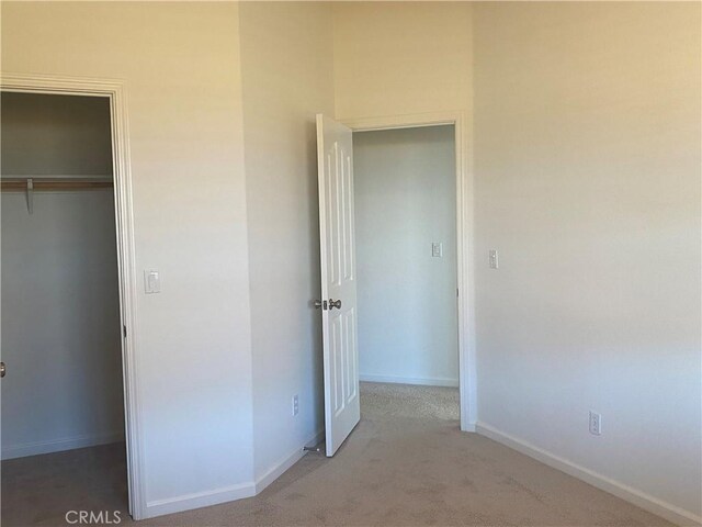 unfurnished bedroom with a closet and carpet flooring