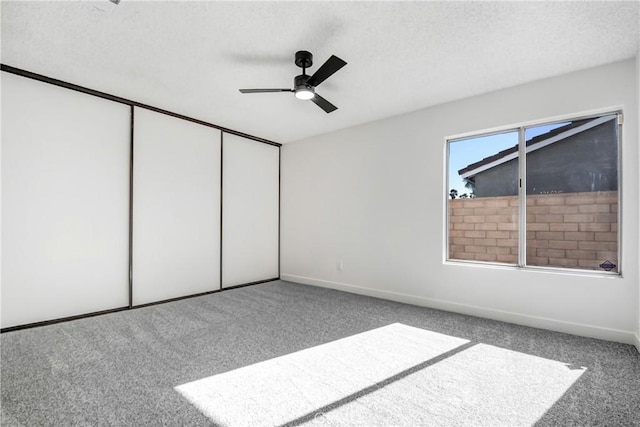 unfurnished bedroom featuring ceiling fan, a closet, and carpet floors