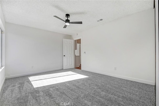 spare room with ceiling fan, a textured ceiling, and carpet flooring