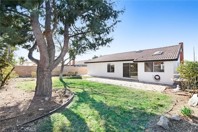 rear view of property featuring a lawn and a patio area