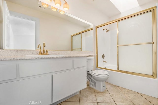 full bathroom featuring tile patterned floors, bath / shower combo with glass door, toilet, and vanity