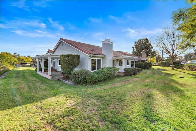 back of house featuring a pergola and a lawn