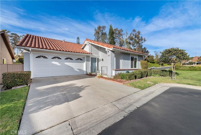 mediterranean / spanish home featuring a garage and a front lawn